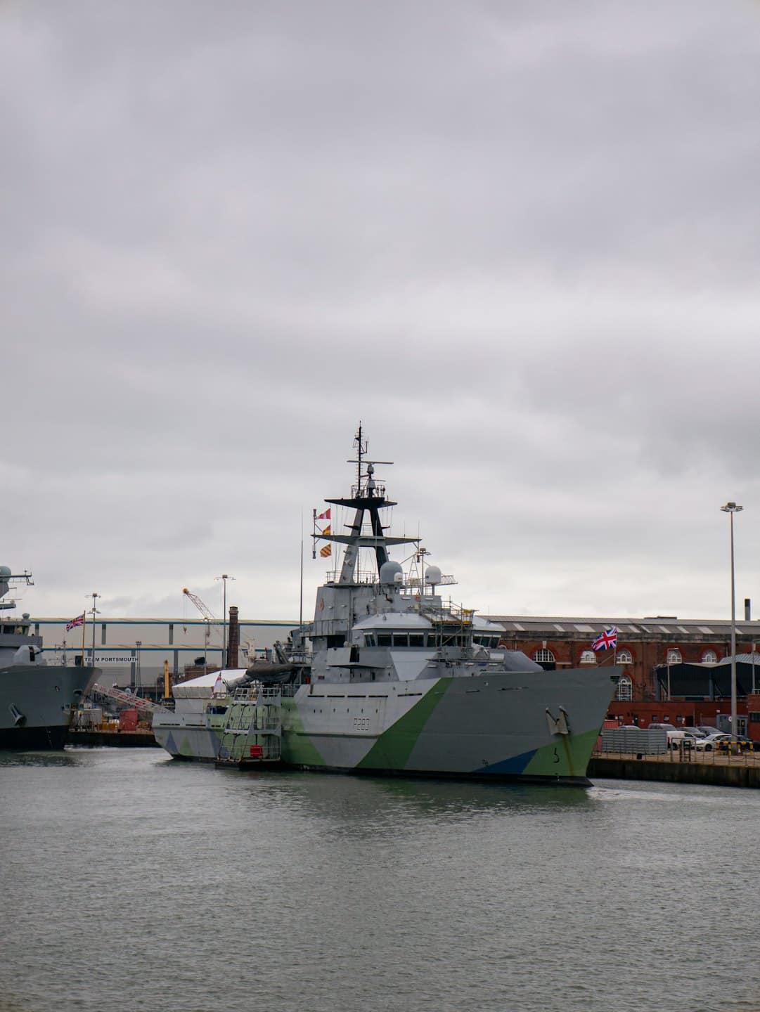 Nave pattuglia militare P287 attraccata a un molo industriale.