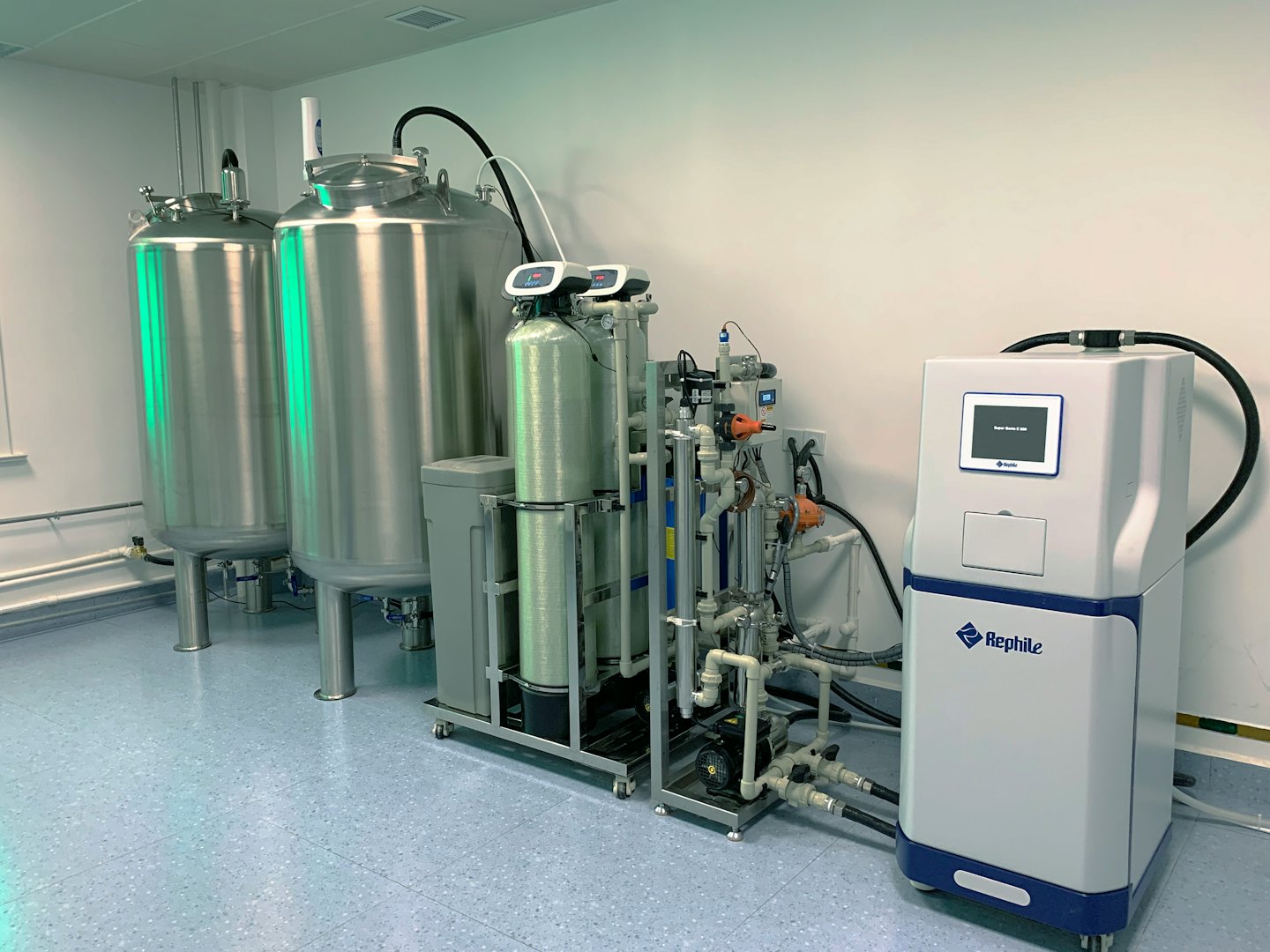 Impianto industriale di purificazione dell'acqua con serbatoi in acciaio inox e unità di filtrazione.